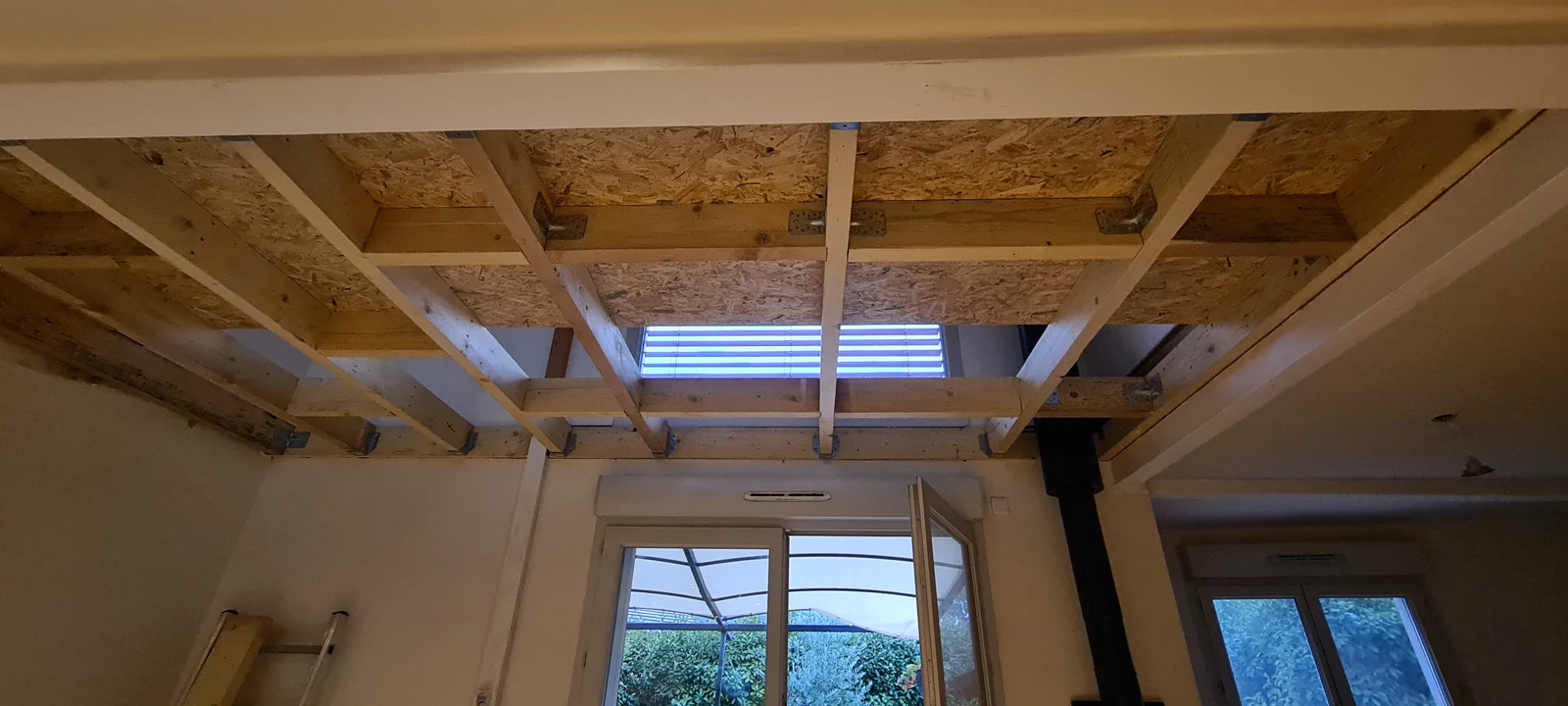 Structure en bois de la mezzanine en cours de pose, vue depuis le séjour à Étrembières